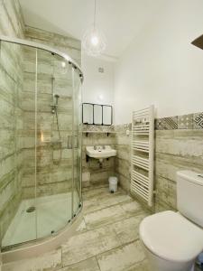 een badkamer met een douche, een toilet en een wastafel bij La Chtite Maison Béarnaise in Arthez-de-Béarn