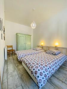 een slaapkamer met een groot bed in een kamer bij La Chtite Maison Béarnaise in Arthez-de-Béarn
