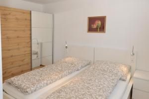 1 dormitorio con 2 camas y una foto en la pared en Apartment Blaser, en Mühlbachl