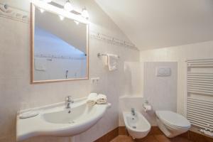 Baño blanco con lavabo y aseo en Wieserhof - Apartment Benjamin, en Valles