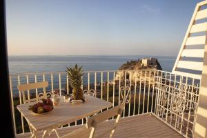 una mesa en un balcón con vistas al océano en Le Tolde del Corallone, en Tropea