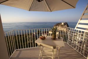 d'un balcon avec une table et une vue sur l'océan. dans l'établissement Le Tolde del Corallone, à Tropea