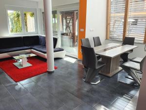 a living room with a couch and a table and chairs at Apartments Akacijev Izvir in Miklavž na Dravskem Polju