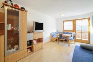 een woonkamer met een tafel en een televisie bij Strickerhof - Appartment 3 in Saltusio