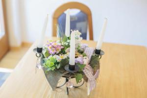 een kaarsenhouder met bloemen op een tafel bij Strickerhof - Appartment 3 in Saltusio