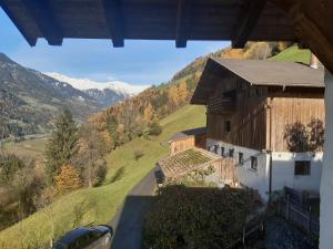 a building on a hill with a view of a mountain at Strickerhof - Appartment 3 in Saltusio +8 photos