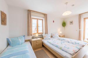 a bedroom with two beds and a window at Ferienwohnungen Holzner groß in Inzell