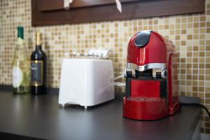 a red coffee maker sitting on a counter with a toaster at Villa Gloma in Capoterra