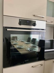 - une cuisine avec une table, des chaises et un four micro-ondes dans l'établissement Apartments Andrej, à Ptuj