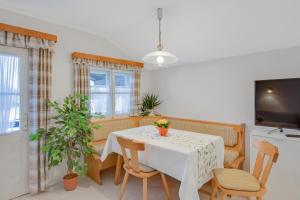 a dining room with a table and chairs and a tv at Ferienwohnung Wennesz 2 in Chieming