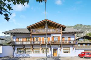 un gran edificio con un balcón en la parte superior. en Katharinenhof Ferienwohnung Zugspitze (5), en Garmisch-Partenkirchen