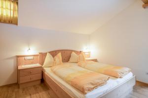 una camera con un grande letto con testiera in legno di Wieserhof - Apartment Philipp a Valles