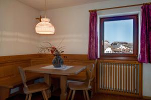 uma sala de jantar com uma mesa e cadeiras e uma janela em Apartment 5 - Zur Sonne em Laion