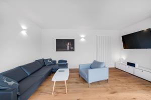 a living room with a blue couch and a table at Ferienhaus Seebruck in Seebruck