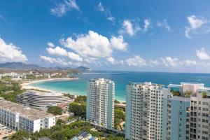 vistas a una playa con edificios y al océano en Sanya Sun and Sea Gueshouse, en Sanya