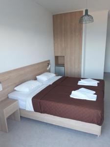 a bedroom with a large bed with towels on it at Calypso in Agia Roumeli