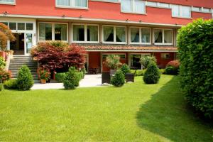 a building with a green lawn in front of it at Hotel San Martino in Boario Terme