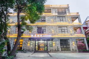 - un grand bâtiment en pierre avec un panneau dans l'établissement Beihai Silver Beach Yintai Time Seaview Villa Hotel, à Beihai