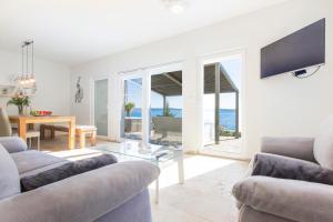 a living room with two couches and a glass table at Dalmata Lounge in Starigrad