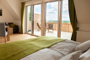 a bedroom with a bed and a view of a balcony at Weingut Assigal in Leibnitz