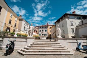 a group of stairs with statues in a city at Studio May in Piran