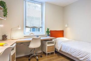 1 dormitorio con escritorio, 1 cama y ventana en Apartment Evita in the old center of sunny Koper, en Koper