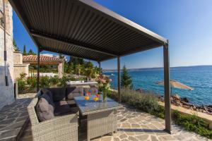 a patio with a couch and a table and the ocean at Dalmata Lounge in Starigrad