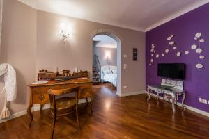 バーリにあるDimora Scipione Crisanzioのデスク付きの部屋、紫の壁のベッドルーム1室が備わります。