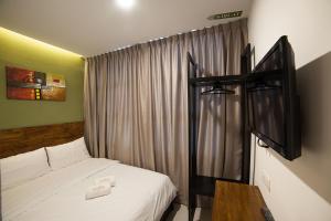 a hotel room with a bed and a window at Econtel Queensbay in Bayan Lepas