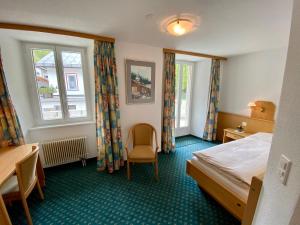 um quarto de hotel com uma cama e uma janela em Hotel Portjengrat em Saas-Almagell