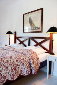 a bedroom with a bed and two lamps and a picture at Hotel Ole Liese in Panker