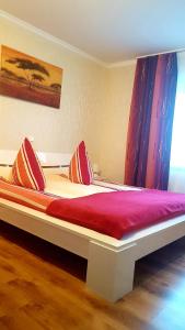 Schlafzimmer mit einem Bett mit roter Bettwäsche und einem Fenster in der Unterkunft Apartment Koblenz in Koblenz