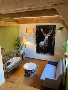 una sala de estar con una pintura de ciervo en la pared en Les Gîtes du Racème, en Blienschwiller