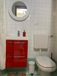 La salle de bains est pourvue de toilettes, d'un lavabo et d'un miroir. dans l'établissement BnButler - Navigli Apartment - Vicolo Lavandai, à Milan
