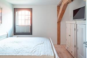 a bedroom with a bed and a flat screen tv at Hafenanker in Barth