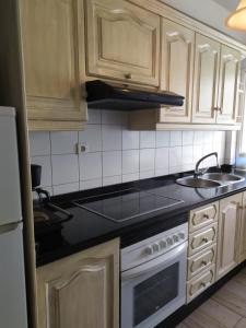 a kitchen with wooden cabinets and a stove top oven at Apartments Tazacorte Beach 2-3 floor in Tazacorte