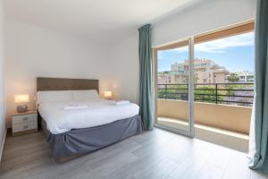 sypialnia z łóżkiem i dużym oknem w obiekcie Marbella Suites w Marbelli