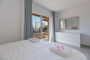 sypialnia z białym łóżkiem i 2 ręcznikami w obiekcie Marbella Suites w Marbelli