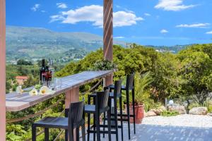 a table and chairs on a patio with a view at Villa Vardis Heated Pool in Vryses