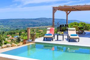 Villa Vardis Heated Pool في Vryses: مسبح مع كرسيين وطاولة وإطلالة