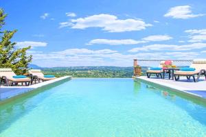 Villa Vardis Heated Pool في Vryses: مسبح مع كراسي وإطلالة على المدينة