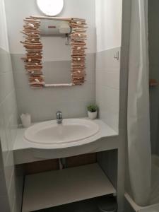 a bathroom with a sink and a mirror at La Calypso in Cavalaire-sur-Mer