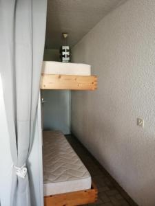 a small bedroom with a bunk bed and a curtain at La Calypso in Cavalaire-sur-Mer