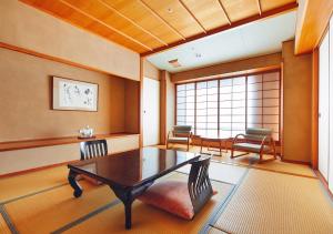 a room with a table and two chairs and a window at Musashi in Shirahama