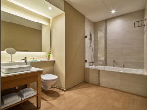 a bathroom with a sink and a toilet and a tub at Hyatt Place Amsterdam Airport in Hoofddorp