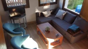z salonu z kanapą i krzesłami w obiekcie Casita Junto al Río Deva w mieście Vilde