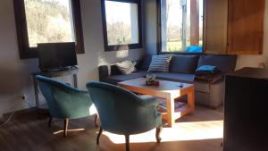 salon z kanapą, krzesłami i stołem w obiekcie Casita Junto al Río Deva w mieście Vilde