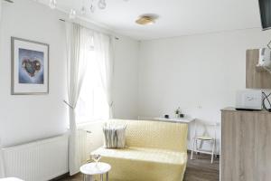 a living room with a yellow chair and a window at Landgasthof Deutsches Haus in Hüttenrode