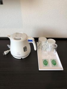 a toaster and two cups on a table at Ai Hotel Keikyu Kamata in Tokyo