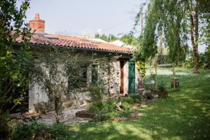 a stone house with a garden in front of it at L'instant jardin in Saint-Mars-de-Coutais
